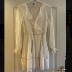 Vit volangklänning från H&M  - Söt vit klänning från H&M med volangdetaljer och v-ringning. Klänningen har lång ärm, markerad midja och lätt struktur i tyget. Perfekt för sommar/student/skolavslutning💗