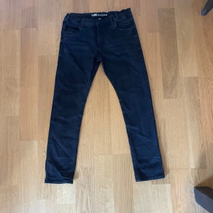 Svarta byxor från LAB Industries - Säljer ett par svarta byxor från LAB Industries i storlek 164. Byxorna har fem fickor, raka ben och klassisk knappstängning framtill. Passar perfekt till dig som gillar en enkel och stilren look.