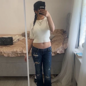 Vit croppad stickad topp - Säljer en vit croppad stickad topp med korta armar, perfekt att matcha med jeans eller kjol. Storlek xs/s