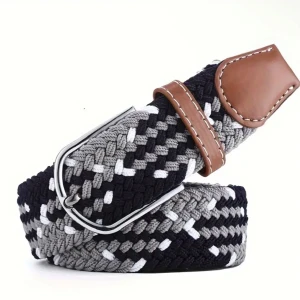 Flätat bälte med bruna skinn-detaljer - Snyggt flätat bälte i svart, grått och vitt med detaljer i brunt skinn och silverspänne. Bältet har en modern look med blandade färger och passar perfekt till jeans eller chinos.