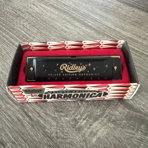 Deluxe Edition Harmonica - Snygg och stilren munspel från Ridley's Deluxe Edition. Perfekt för dig som vill testa på musik eller lägga till ett coolt instrument i din samling!! Några år gammal men använd endast 1 gång!