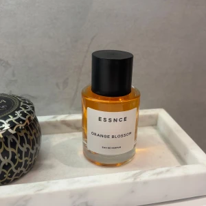 ESSNCE Orange Blossom parfym 50ml - Fräsch Eau de Parfum från ESSNCE med doft av orange blossom. Kommer i en stilren, rund glasflaska med svart lock och vit etikett. Innehåller 50 ml och har inslag av limonene, linalool, citronellol, eugenol och citral. Perfekt för dig som gillar blommiga och fruktiga dofter.