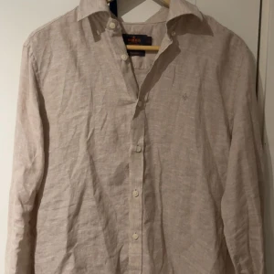 Beige linneskjorta från Morris - Säljer en ljus beige skjorta från Morris i 100% linne. Köpte den för ca 1800 kr men säljer den för betydligt mycket mindre. Priset är inte hugget i sten och kom gärna med förslag eller frågor!