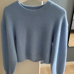 Ljusblå fluffig stickad tröja H&M - Supermjuk och fluffig ljusblå stickad tröja från H&M Divided. Tröjan har rund halsringning och långa ärmar, perfekt för lager-på-lager under kyliga dagar. Enkel och stilren modell som är lätt att matcha med jeans eller kjol.
