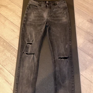 Grå slitna jeans från Le Breve - Snygga grå jeans från Le Breve med slitna detaljer och hål på båda benen. Modellen har en smal passform och klassisk femficksdesign. Jeansen har en tvättad look och är tillverkade i bomullsmix för en bekväm känsla. Jeansen är i bra skick. Passar dig som föredrar byxor som låter dina ben andas, om du har några funderingar så skriv till mig. Öppen för prisförslag😆
