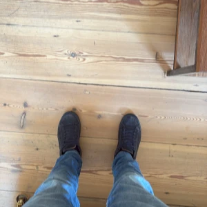 Svarta mockasneakers med snörning - Säljer ett par svarta sneakers i mocka med klassisk rund tå och platt sula. Skorna har svarta skosnören och en stilren, enkel design som passar till jeans eller andra vardagsoutfits. Perfekta för dig som gillar en clean och tidlös look.