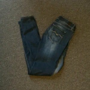 Blå Replay jeans, 27/32 - Snygga blå jeans från Replay med klassisk femficksdesign och Modellen har normal midja och raka ben. Jeansen har kontrastsömmar och är tillverkade i mjukt denimtyg som sitter skönt hela dagen.