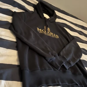 Mörkblå Morris hoodie - Säljer denna feta Morris hoodie i mörkblå, skicket är bra i tanke med att den är ganska gammal runt 9, inga defekter på hoodien. Storlek S passar 170-180 skulle jag säga. Hör av er vid frågor eller funderingar. Nypris runt 1499 säljs knappt längre i denna modell