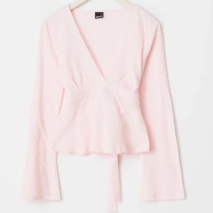 Ljusrosa omlottopp med knyt - Supersöt ljusrosa omlottopp från Gina Tricot med v-ringning och långa ärmar. Toppen har knyt i midjan som ger en snygg look. Toppen är i nyskick, endast använd 2 gånger. PRIS KAN DISKUTERAS!💕