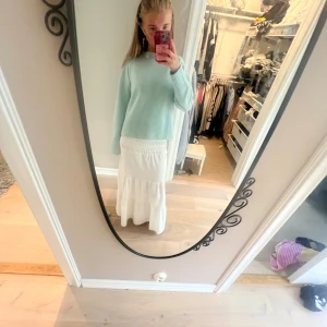 Vit långkjol med volang - Supersöt vit långkjol med smock i midjan och volangdetaljer. Kjolen har en flowy och luftig känsla, perfekt för varmare dagar. Passar dig som gillar en romantisk och avslappnad stil. Så så fin och inte alls genomskinlig❣️ passar S-Xs