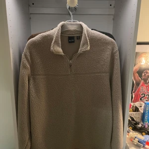 Beige fleece-tröja Only & Sons - Mysig beige fleece-tröja från Only & Sons med halv dragkedja och hög krage. Perfekt för kyliga dagar, tröjan har lång ärm och en loose fit som ger en avslappnad vibe. Supermjuk och skön att bära, passar perfekt till jeans eller joggers. Aldrig använd