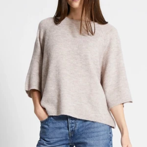 Beige kortärmad stickad tröja  - Supermjuk och oversized beige stickad tröja från 157. Tröjan har trekvartsärmar, rund halsringning och en loose fit. 