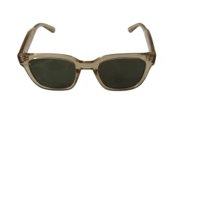 Beige  solglasögon H&M liknar chimis - Snygga solglasögon från H&M med transparent beige båge och fyrkantig form. Glasen är mörka och ger en cool vibe till din outfit. Perfekta för soliga dagar när du vill sticka ut lite extra.