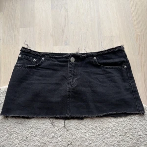 Svart jeanskjol - ÄLSKAR denna kjol, sjukt snygg lågmidjad jeanskjol. Midjemåttet är 37/38. Längden på sidan är 26 cm