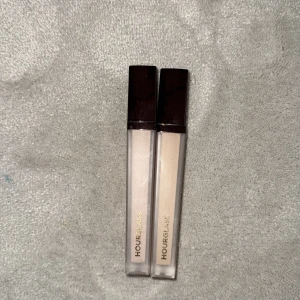 Hourglass concealer duo - Två flytande concealers från Hourglass i smidiga fyrkantiga tuber med mörkbruna lock. Nyansen är ljusbeige och passar perfekt för att ljusa upp under ögonen eller täcka blemmor. Snygg och stilren design med guldtext på förpackningen i färgerna creme och sepia.
