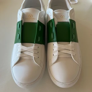 Valentino Garavani Open sneakers vit/grön - Snygga Valentino Garavani Open sneakers dessa skor är i top kvalité. Låda och påsen får du med. Lådan är lite skadad men skorna har inte någon skada eller smuts på sig. Hör av dig om du är intresserad 