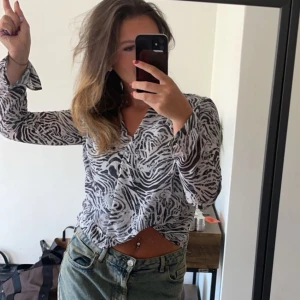 Zebramönstrad blus - Säljer en snygg zebramönstrad blus med v-ringning. Blusen har långa ärmar och en lös passform, perfekt för en trendig look. 🖤🤍