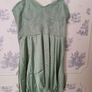 Grön klänning från Romwe - Snygg grön klänning från Romwe med spetsdetaljer upptill och justerbara axelband. Tillverkad i polyester vilket ger ett fint fall. Perfekt för en stilren look.