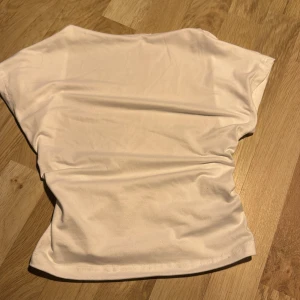 Vit topp från Shein - Säljer en backless vit topp från Shein. Toppen har en enkel design med korta ärmar och är tillverkad i ett mjukt och stretchigt material. Perfekt för en avslappnad look.