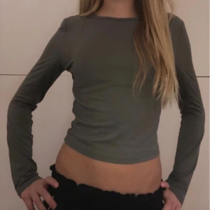 Grå långärmad topp från Shein - Säljer en stilren grå långärmad topp från Shein. Toppen är croppad och har en enkel design som passar perfekt till vardags. Materialet är mjukt och bekvämt.