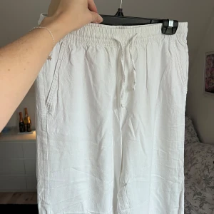 Vita linnebyxor med resårmidja - Säljer ett par vita linnebyxor med resårmidja och avslappnad passform. Byxorna har fickor på sidorna och en bakficka. Perfekta för en bekväm och stilren look. Använda 2-3 gånger. Önskar du veta exakta mått? Tveka inte att höra av dig!
