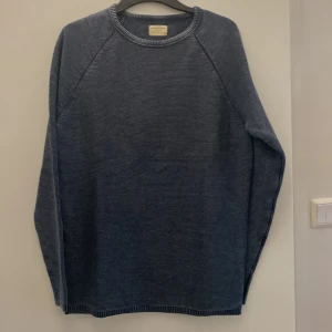 Blå stickad tröja från Selected Homme - Säljer en stilren blå stickad tröja från Selected Homme. Tröjan har en rund halsringning och långa ärmar, perfekt för kyligare dagar. Den är tillverkad i ett mjukt material som ger en bekväm passform. Passar bra till både jeans och chinos.