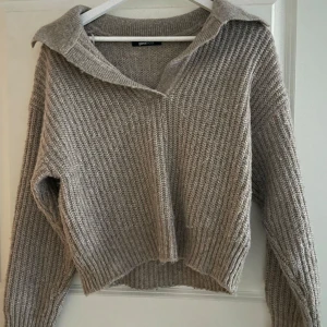 Beige stickad tröja från Gina Tricot - Mysig beige stickad tröja från Gina Tricot med en avslappnad krage. Perfekt för kyliga dagar med sin ribbade textur och långa ärmar. En stilren och bekväm tröja för alla tillfällen.💕