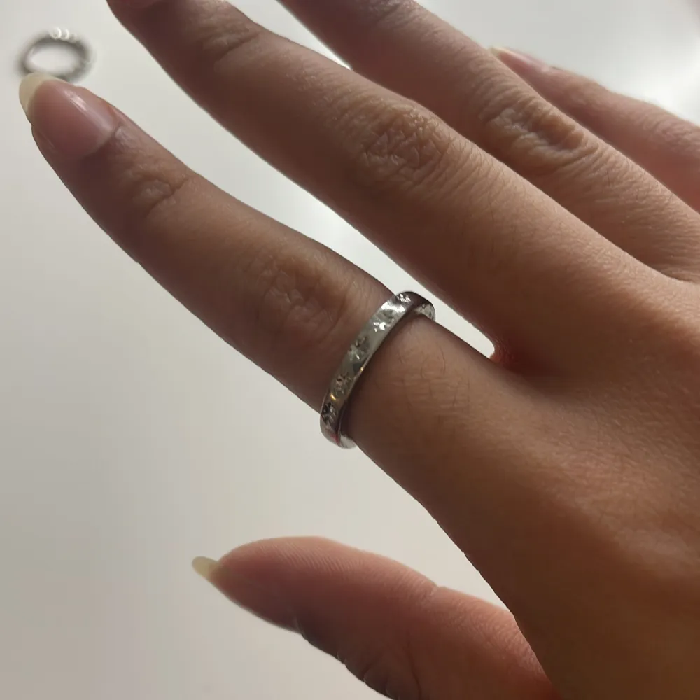 Säljer en stilren och enkel silverfärgad ring med stjärn design. Perfekt accessoar för att komplettera din stil.. Asusteet.