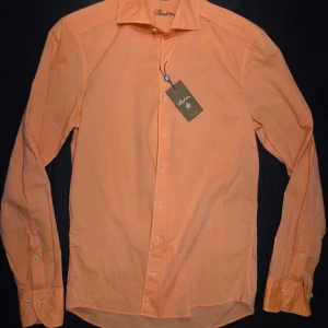 Helt ny skjorta från Stenströms - Säljer en persikofärgad skjorta från Stenströms med klassisk krage och vita knappar. Skjortan har lång ärm och är i slim fit-modell. 