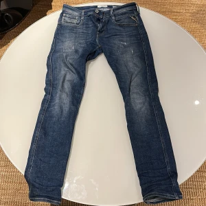 Blå Replay Anbass jeans - Säljer ett par klassiska blå Replay Anbass jeans med normal passform och raka ben. Knappt använda alls och ser helt nya ut. 