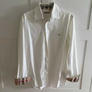 Burberry skjorta - Säljer nu min vita skjorta från Burberry som är i jättebra skick,10/10. Priset är inte hugget i sten:)