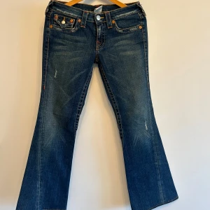 True Religion - Säljer ett par äkta True Religion jeans. Snygga bakfickor med klassiska True Religion detaljer. Jeansen är i fint sick och passar både till vardags eller för att klä upp med en festtopp!! 💕{ Längd: 92cm, Innerbenslängd: 71cm}