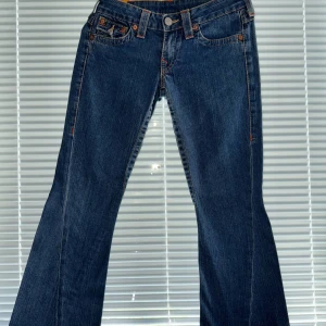 True Religion  - Säljer ett par äkta True Religion jeans i lågmidja. Snygga bakfickor med klassiska True Religion detaljer. Jeansen är i fint sick och passar både till vardags eller för att klä upp med en festtopp!! 💕{ Längd: 92cm, Innerbenslängd: 72cm}. 