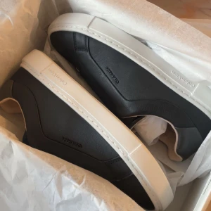 Svarta sneakers från Calvin Klein - Säljer ett par stilrena svarta sneakers från Calvin Klein med vit sula. Skorna har en minimalistisk design med diskret logga på sidan och häl. Perfekta för en clean och modern look. Köpte för 1121kr säljer för 900kr