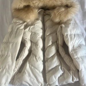 jättesöt jacka med päls  - säljer en superfin vit jacka päls , pälsen går att ta av. knappt använd, bra o nytt skick !! köpt secondhand för 1000kr. lite målarfärg på ärmen dock !! står att storleken är S men passar XS, S, M 