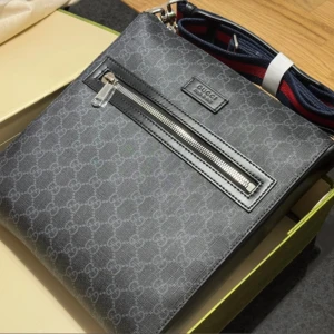 Svart axelväska från Gucci med monogram - Det går att pruta ner vid snabb affär.  Snygg svart axelväska från Gucci med klassiskt GG-monogram och silverfärgad dragkedja framtill. Väskan har en justerbar axelrem i blått och rött, samt detaljer i skinn. Perfekt för att bära det viktigaste med stil. 