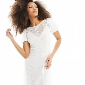 Vit långklänning med spetsdetaljer - Helt nytt skick med lapp, aldrig använd. vit långklänning med blommig spets upptill och transparent mesh vid halsringningen. Klänningen har korta puffärmar och sitter jättefint! Säljer då den inte passar och jag missade returneringen! Nypris 732 kr. Skriv för fler bilder eller vid andra frågor😇