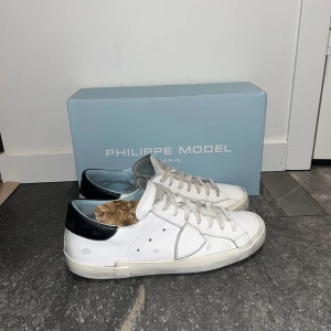 Vita sneakers från Philippe Model - Tja säljer ett par sjukt feta Philippe Models. Jag säljer dom för att dom har blivit för små för mig. Storlek 41 men passar även 42 7/10 skick. Ända defekten är att dom är lite slitna på sulan vid hälen. Priset är ej hugget i sten. Hör av er vid minsta fundering 🤩