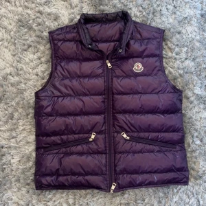 Moncler RARE CW Gui Väst - Moncler Gui Väst RARE CW Lila Herrmodell som funkar lika bra till herr som dam!  Skick: 9/10 Storlek: 2 (S/M) Nypris: 9260kr pris: 4990kr Frakt: (Hemlevererat spårbart)📦  Tveka inte att höra av dig vid minsta frågan!