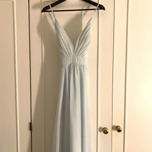 Ljusblå långklänning med smala axelband - Ljusblå balklänning köpt från Ivory Field förra året. Den är endast använd en gång och säljer pga att jag inte har användning för den. Det är storlek 4, passar mig som har strl S.💕