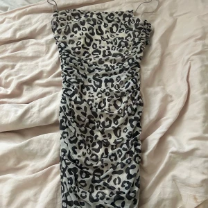 Leopardmönstrad tight klänning - Säljer en tight klänning med leopardmönster och tunna axelband. Klänningen har en figurnära passform.
