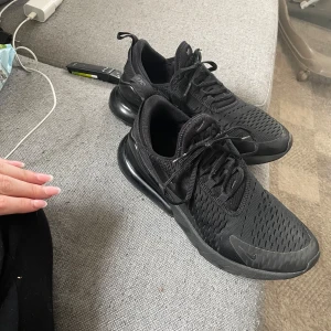 Svarta Nike Air Max 270 sneakers - Säljer ett par helsvarta Nike Air Max 270, det ända som är fel är det ni kan se på bild 2. Dim är i storlek 41 men passar mig med 40 och öven min mamma med 39. Hör av er om ni har frågor 😊🩷