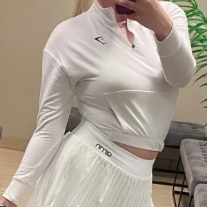 Vit croppad hoodie från Gymshark - Säljer en vit croppad hoodie från Gymshark med halv dragkedja och lång ärm och elastisk nederkant. Storlek S, stretchig funkar även som M🤍 