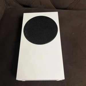 Xbox Series S spelkonsol - Säljer en vit Xbox Series S spelkonsol med svart cirkulärt ventilationsgaller. Konsolen har flera USB-portar, HDMI-utgång och nätverksanslutning. Kompakt och stilren design, perfekt för gaming och streaming. Kommer med ingen kontroller kan ta 2000 o skickas samma dag. 