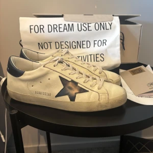 Golden goose skor  - Riktigt snygga Golden goose skor] beige/vita och mörkblåa, perfekta skor för sommaren och våren] Köpta för 4000kr hos merchsweden, kvitto finns. Använda ungefär två månader så skicket är mycket bra, endast lite crease. Storlek 41. Hör av er vid funderingar 
