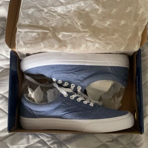 Blå sneakers från Polo Ralph Lauren - Aldrig använda, prislappen är kvar. Jeans tyg. Funkar för både killar och tjejer.