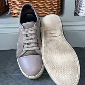 Lanvin skor - Säljer ett par stilrena grå sneakers från Lanvin. Lite slitningar inuti skon men i övrigt riktigt bra skick. Perfekta för dig som gillar en clean och klassisk look.⭐️
