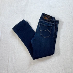 Mörkblå jeans från Jacob Cohën - Snygga mörkblå jeans från Jacob Cohën med klassisk femficksdesign och raka ben. Jeansen har en stilren look och är i väldigt bra skick! Lång W32. Har du några funderingar eller liknande så är du mer än välkommen att fråga!