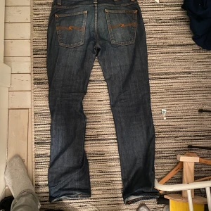 Mörkblå jeans från Nudie Jeans - Säljer ett par klassiska nudie jeans mörklblåa som är lite för stora på mig tyvärr