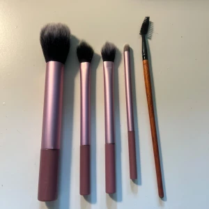 Set med sminkborstar  - Säljer ett set med fem sminkborstar var av frys i rosa/lilla fluffiga borstar samt en ögonbrynsborste. Perfekt för applicering av puder, ögonskugga och bryn. Alla borstarna är oanvända 💗